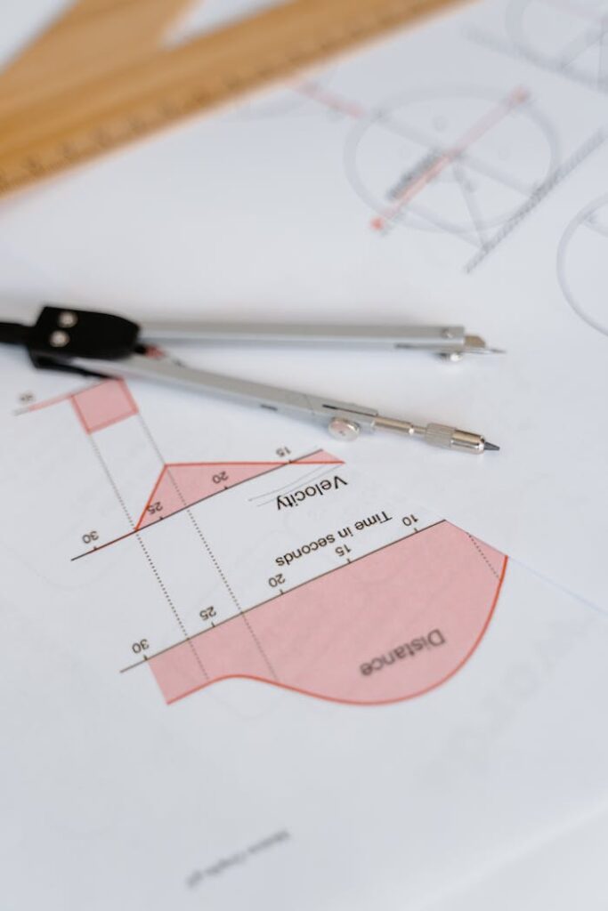 Close-up of a Compass on a Paper with Graphs